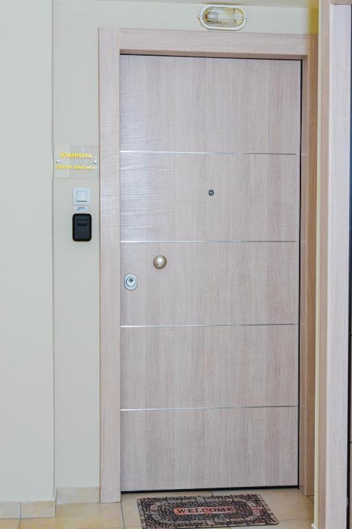 a wooden door in a room with a rug at Ioannina Center Apartment in Ioannina