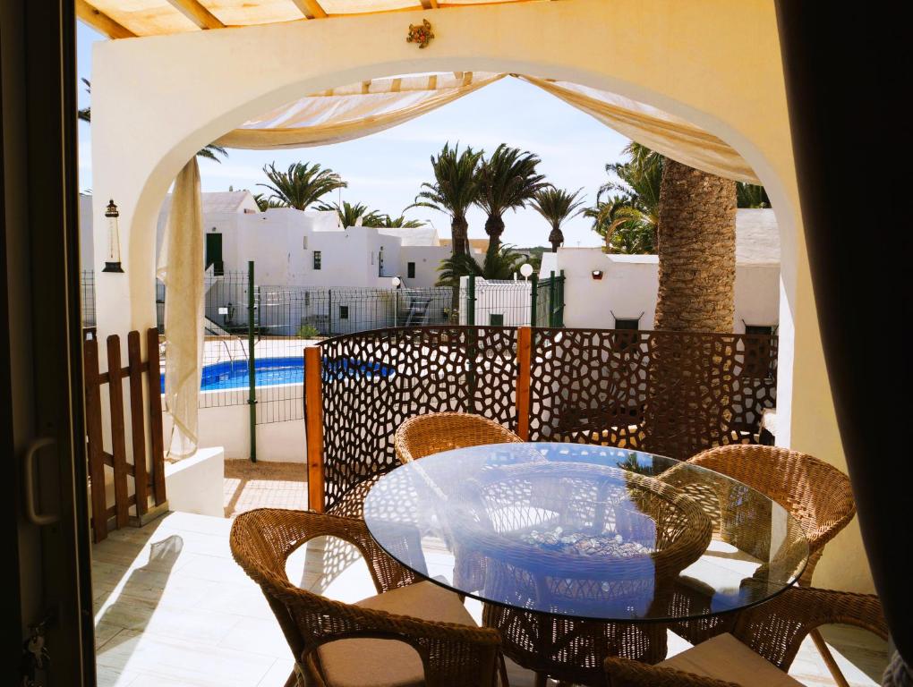 a patio with a glass table and chairs on a balcony at Casa del Capitan in Costa Calma