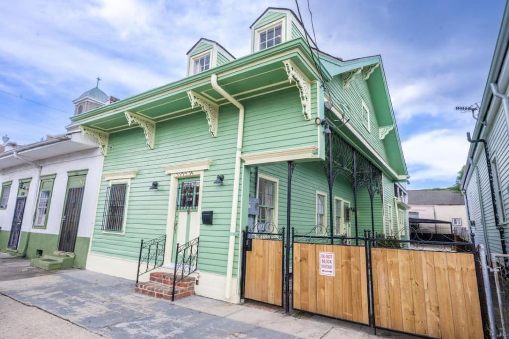a green and white house with a wooden fence at Mandeville Creole Cottage - 3 bed-2 bath in New Orleans