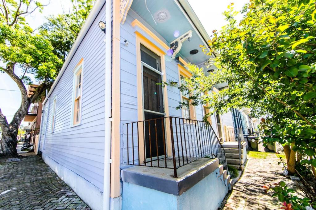 a blue house with a balcony on the side of it at Kerlerec Victorian Cottage - Steps to French Qtr. in New Orleans