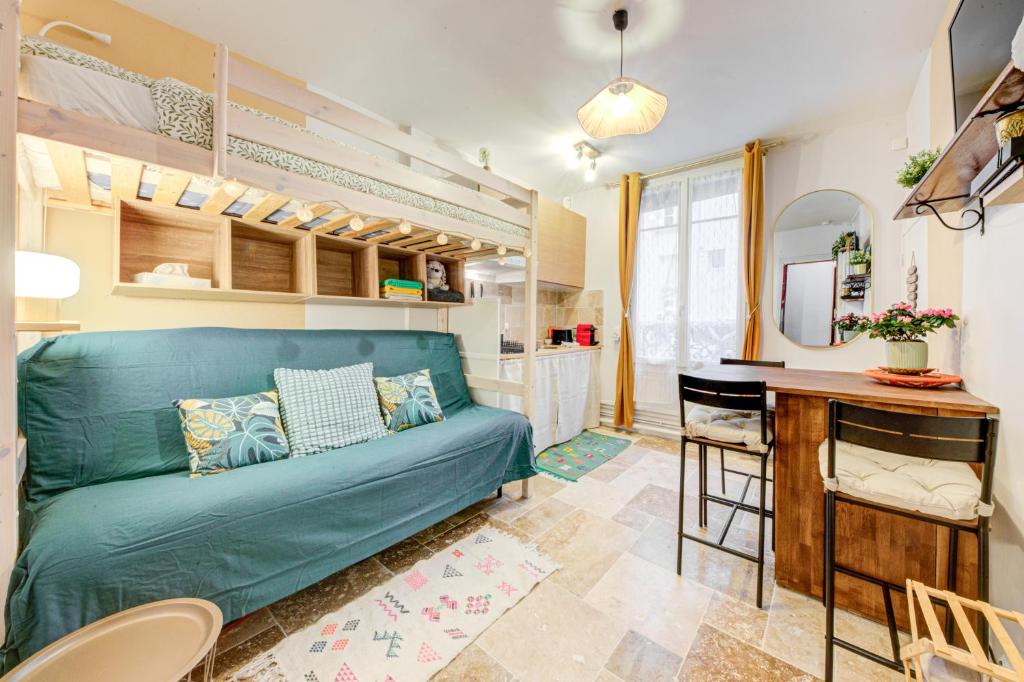 un salon avec un canapé bleu et une table dans l'établissement Appartement où il fait bon vivre, à Paris