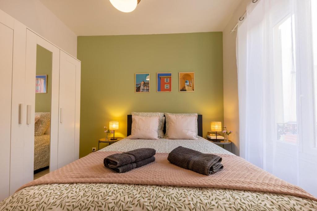 une chambre avec un grand lit avec deux oreillers dessus dans l'établissement Joli cocon à 3 min à pied de la mer, à Nice