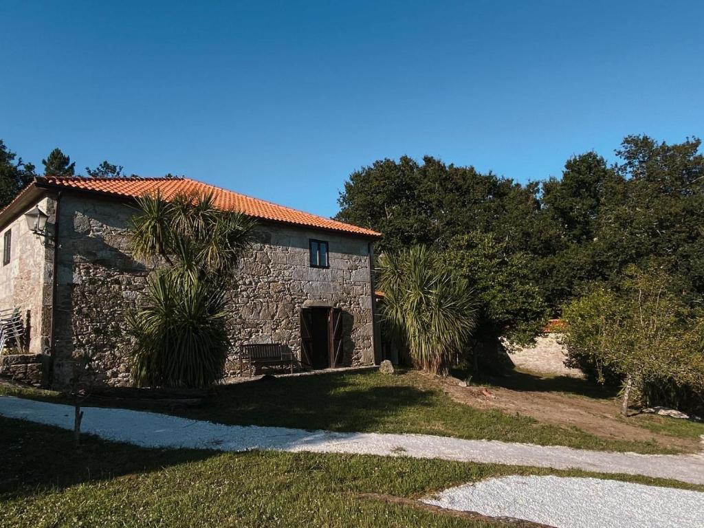 ein Steingebäude mit einer Palme davor in der Unterkunft Valfrescosuites&relax in Pontevedra