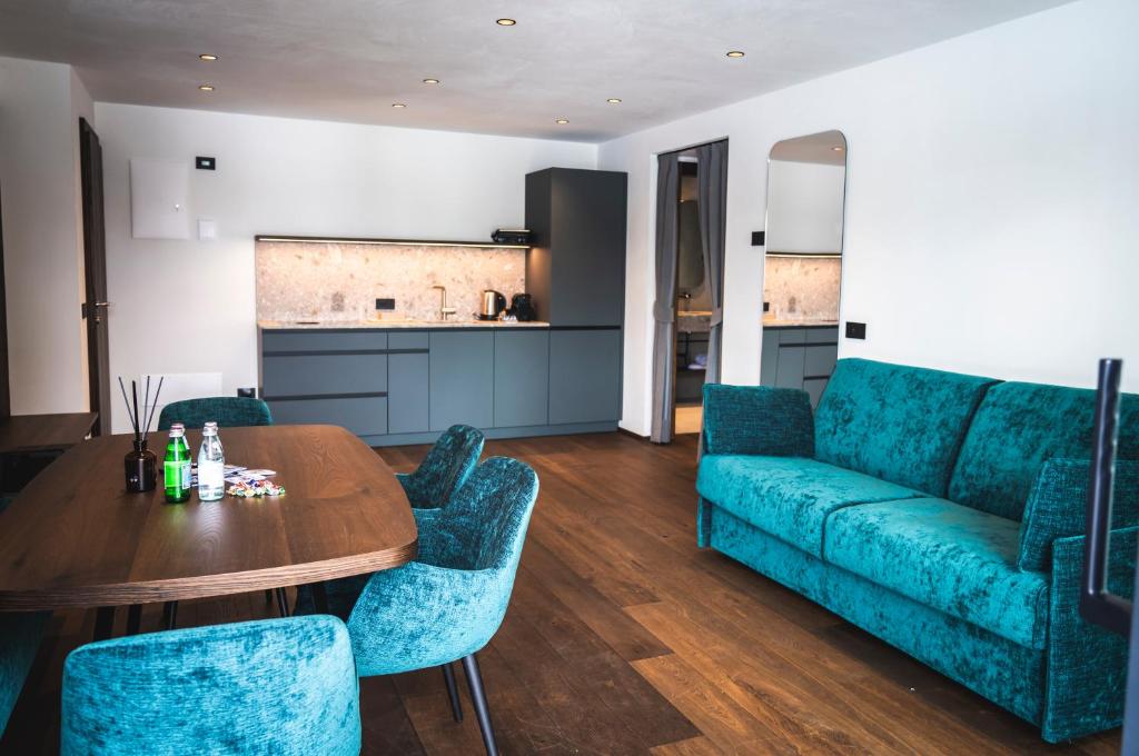 un soggiorno con un divano blu e un tavolo di Manu Apartments a Livigno