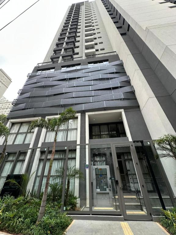 un edificio alto con una puerta giratoria delante de él en Paraíso SPA only with Pool and Sauna TOP !, en São Paulo