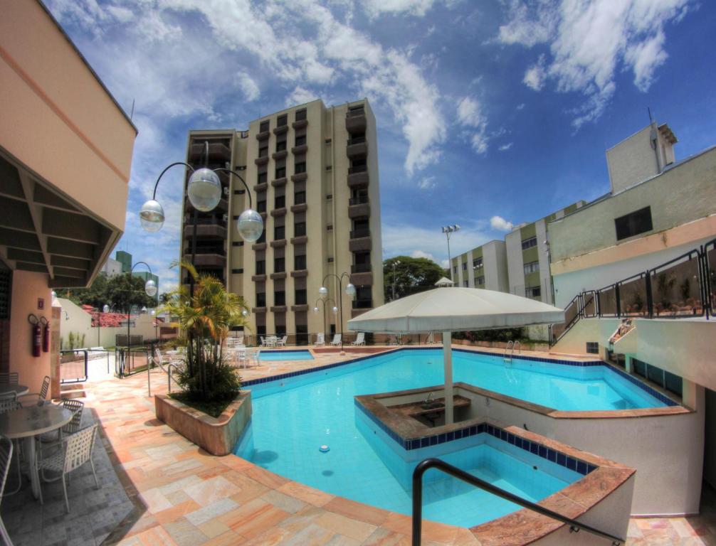 a large swimming pool in front of a building at Hotel Ema Palace in São José dos Campos