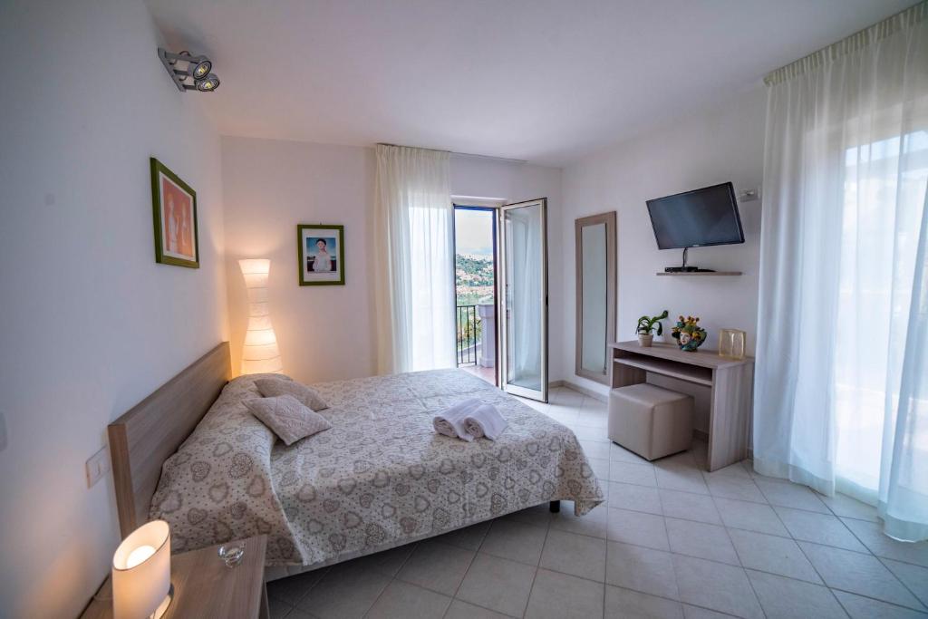 タオルミーナにあるMastrissa Country Houseのベッドルーム(ベッド1台、テレビ、窓付)