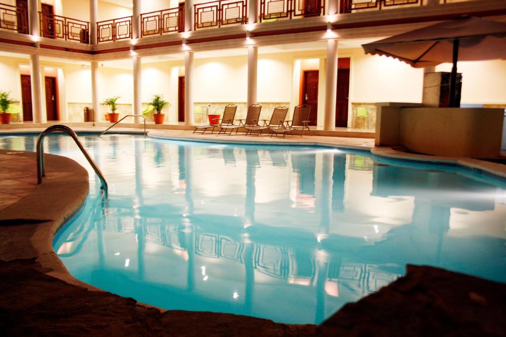 a large swimming pool in a large building at Hotel Plaza Maria in Catacamas