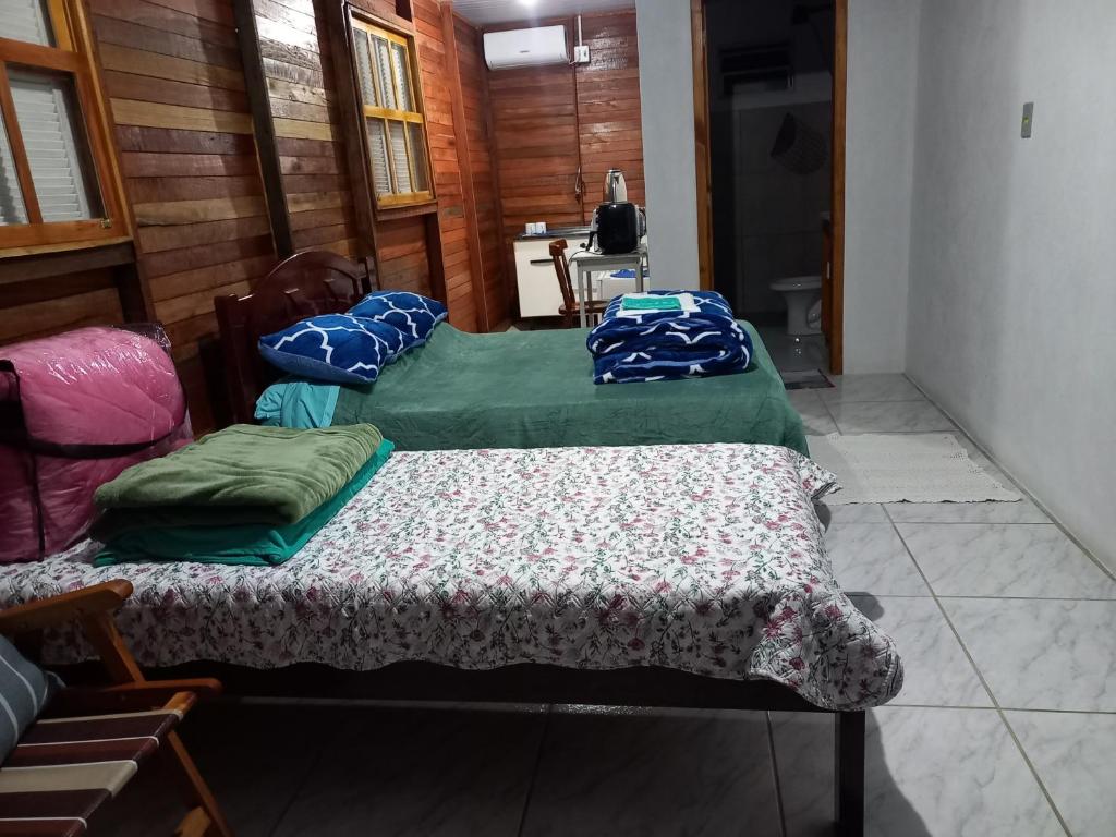 two beds are sitting in a room with at Pousada Germânia Paraíso do Sul in Paraíso do Sul