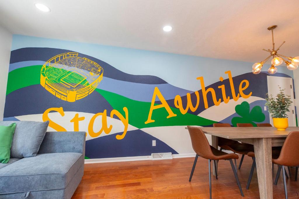 a living room with a table and a sign on the wall at Game room Hot tub Fire pit 2 miles to ND in South Bend