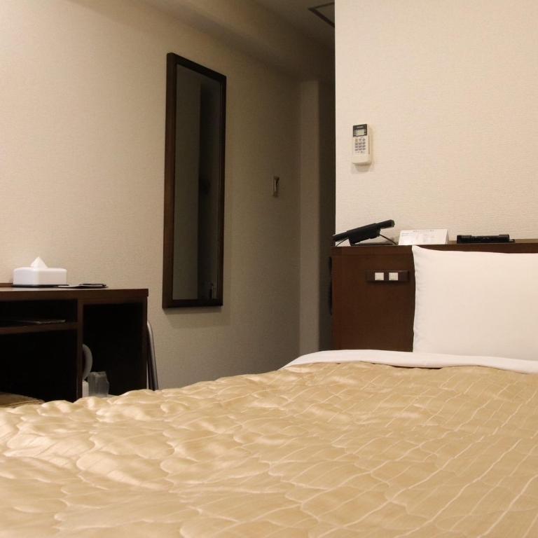 Postel nebo postele na pokoji v ubytování サンホテル尼崎