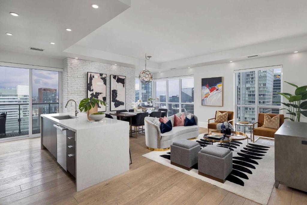 a living room with a lot of furniture and windows at Skyline Royale Penthouse - Downtown Toronto - CN Tower View, Balcony, Pool, Hot Tub in Toronto