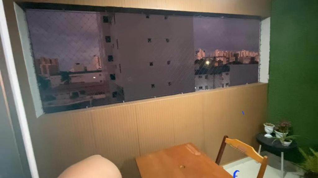 a room with a table and a window with a view at Apto Caldas Novas in João Pessoa