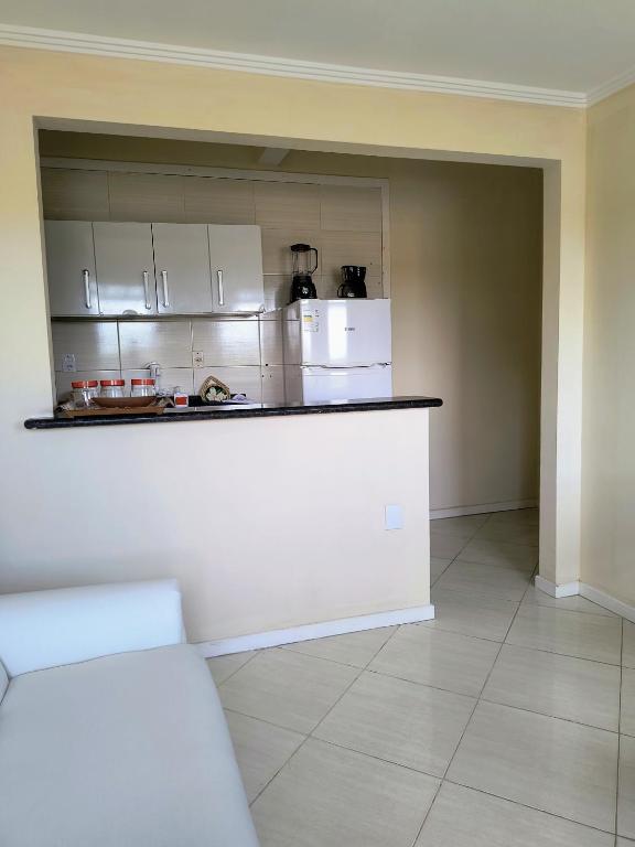 uma cozinha com armários brancos e uma bancada em Espaço aconchegante em Camaçari