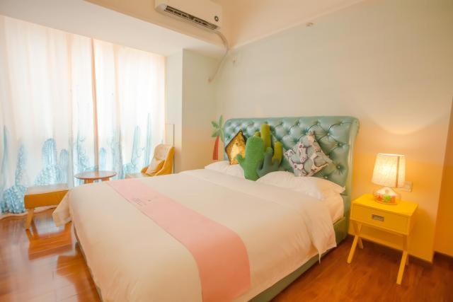 a bedroom with a large bed with a stuffed animal on it at FRAGRANCE House Hanxi Changlong Panyu Wanda Plaza Store in Guangzhou