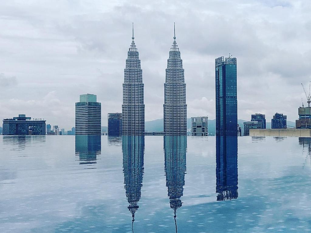 una vista de las torres gemelas Petronas reflejadas en el agua en Eaton KLCC Suites By Elite, en Kuala Lumpur