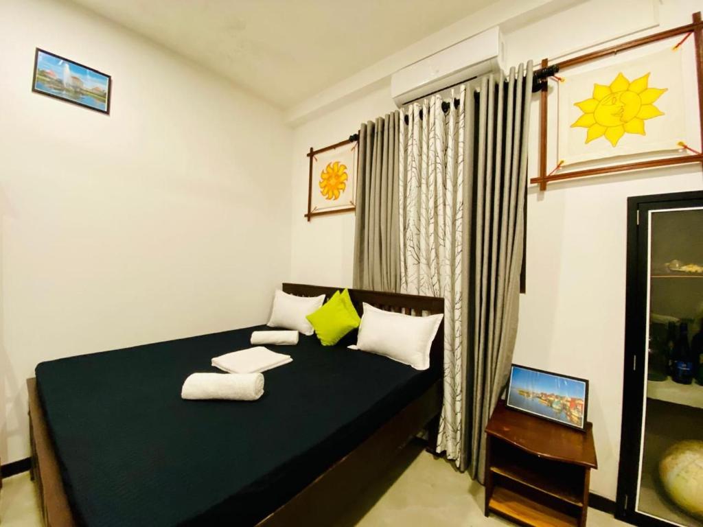 Un dormitorio con una cama negra con almohadas y una ventana en New White Villa Ahangama, en Ahangama