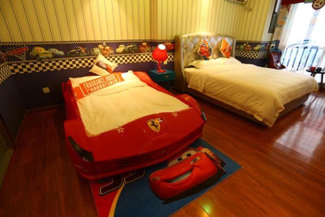 a bedroom with two beds and a suitcase on the floor at FRAGRANCE House Hanxi Changlong Panyu Wanda Plaza Store in Guangzhou