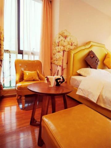 a bedroom with a bed and a table and a chair at FRAGRANCE House Hanxi Changlong Panyu Wanda Plaza Store in Guangzhou