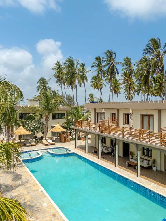 an image of a pool at a resort with palm trees at Blackstone Beach Resort in Uroa