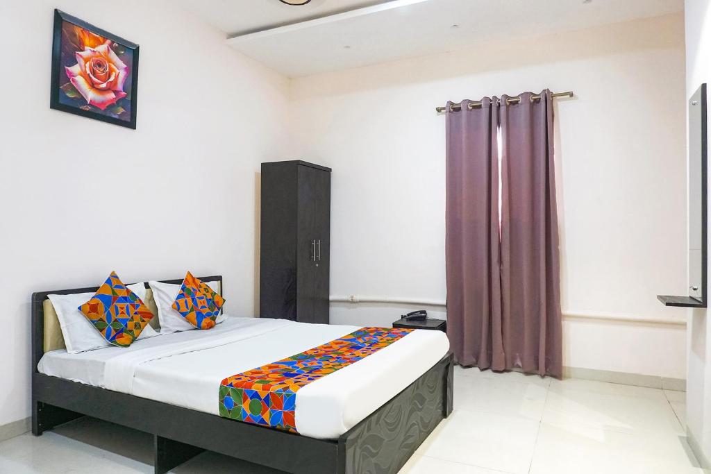 a bedroom with a bed with a purple curtain at FabHotel Rachana Residency - Nr Shivaji Nagar Metro Station in Pune