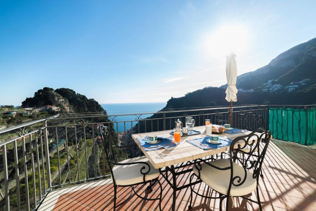 a table and chairs on a balcony with a view of the ocean at Ferriere Apartment in Scala