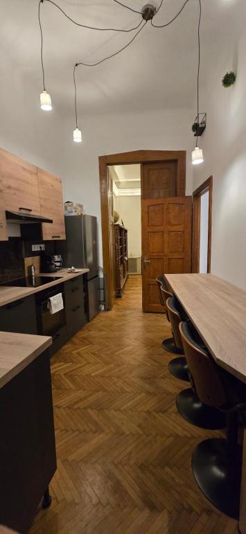 an empty kitchen with a long table and chairs at Moods Apartmans in Szeged