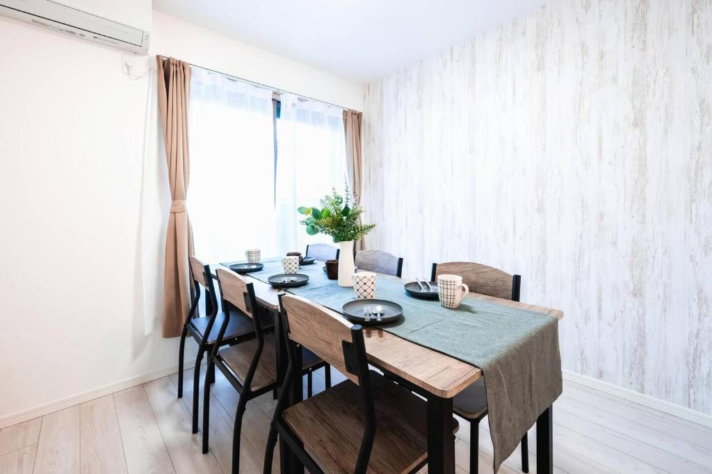 ein Esszimmer mit Tisch und Stühlen und einem Fenster in der Unterkunft White Hotel Tsuruhashi in Osaka