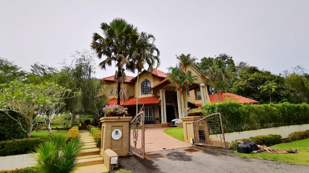 una casa con una palmera delante en Tiara Golf Villa With Pool, en Melaka