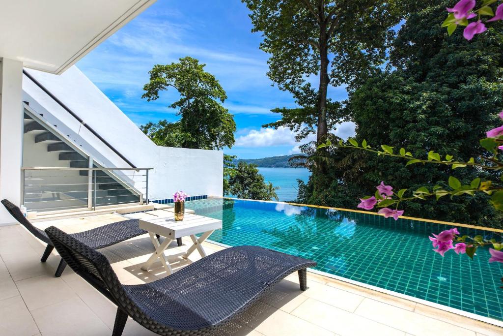 a patio with a table and chairs next to a swimming pool at Private 3-Storey Pool Villa Atika 10, for 7, views of Patong Bay in Patong Beach