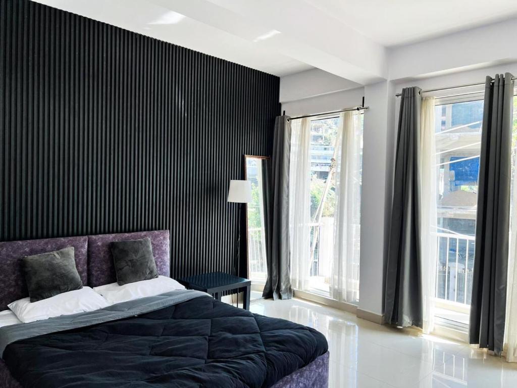 a bedroom with a purple bed and windows at TeTia stay in Kohīma