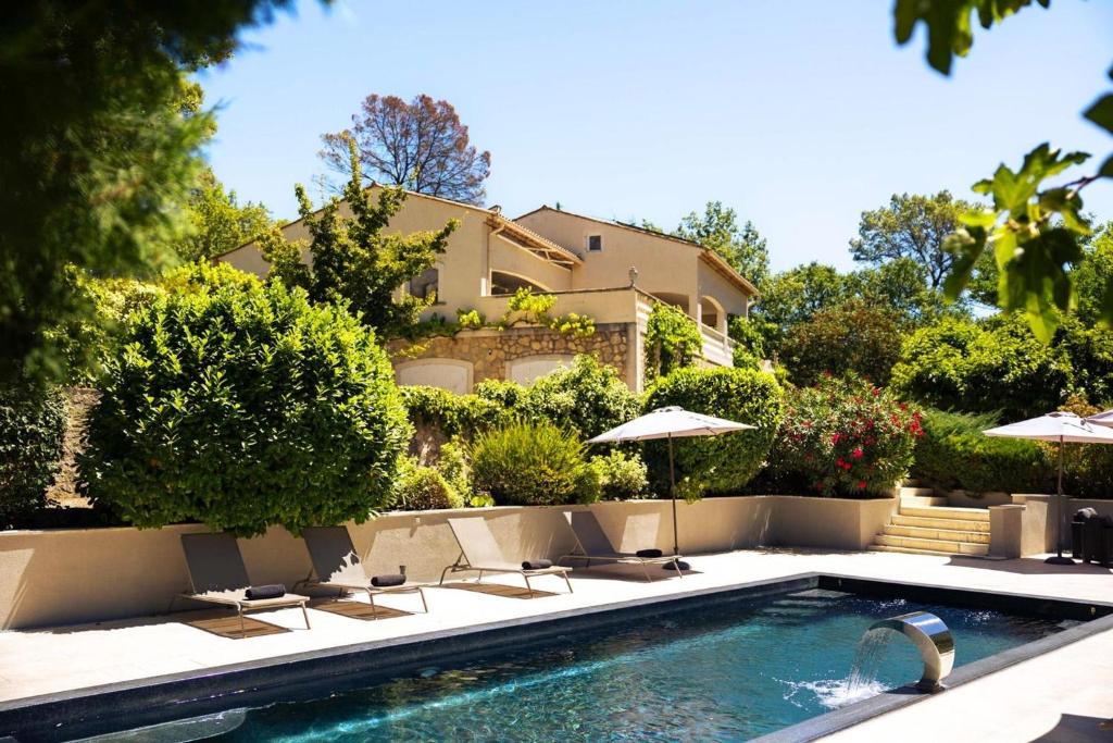 - une piscine avec des chaises et des parasols en face d'une maison dans l'établissement Charming Villa in the South of France with Private Pool and Gardens, à Tourrettes