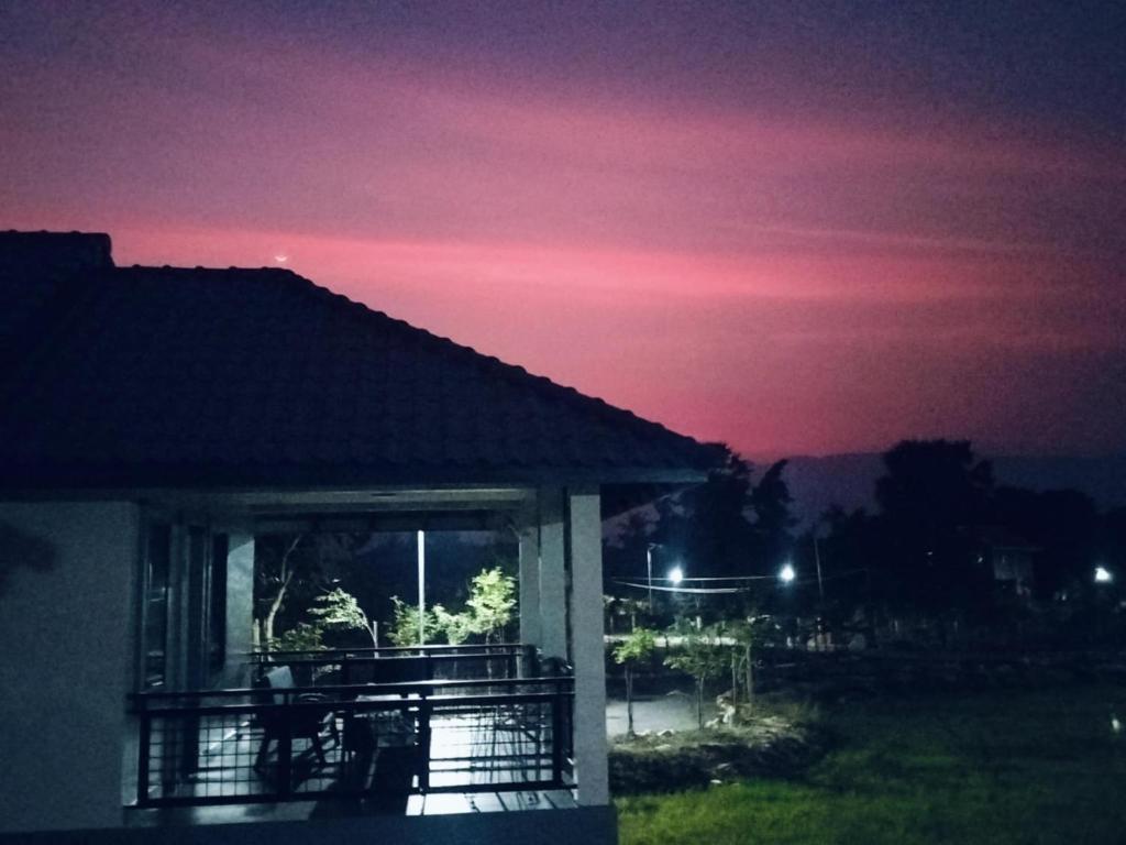 a night view of a house with a sunset at Baksaei Retreat Ricefield Villas in Kampot