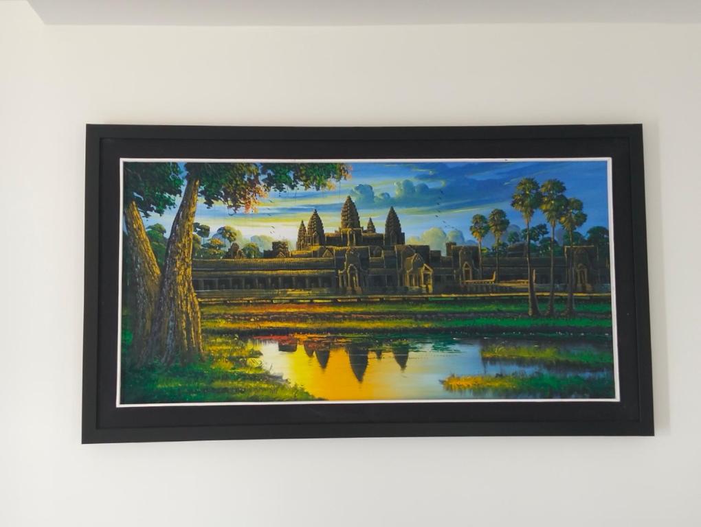 a framed painting of a temple and a lake at Baksaei Retreat Ricefield Villas in Kampot