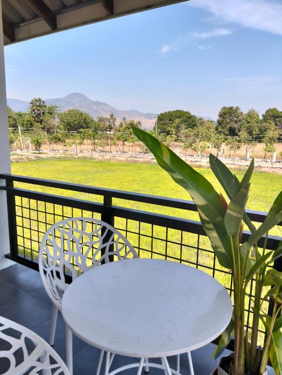 a white table and chairs on a balcony at Baksaei Retreat Ricefield Villas in Kampot