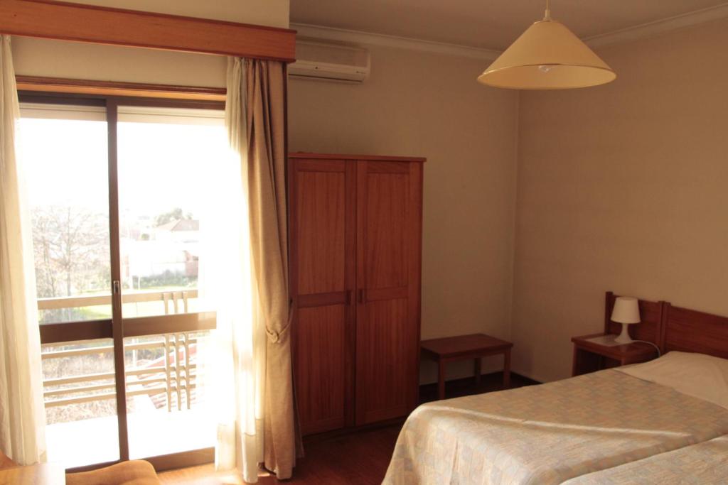 Postel nebo postele na pokoji v ubytování Residencial Dom Manuel
