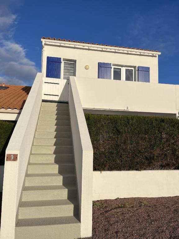 Un escalier mène à une maison blanche. dans l'établissement Cosy Fermette, à Saint-Jean-de-Monts