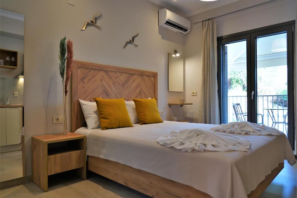 una camera da letto con un letto grande con cuscini gialli di MERAVIGLIA a Párga