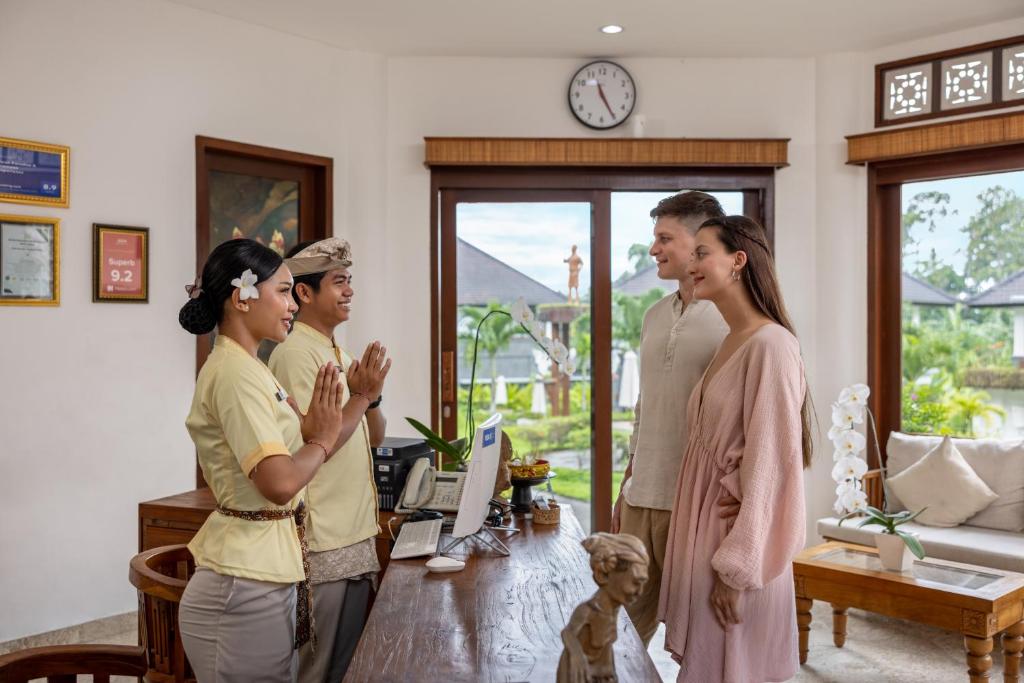 a group of people standing in a living room at Swan Paradise A Pramana Experience in Gianyar
