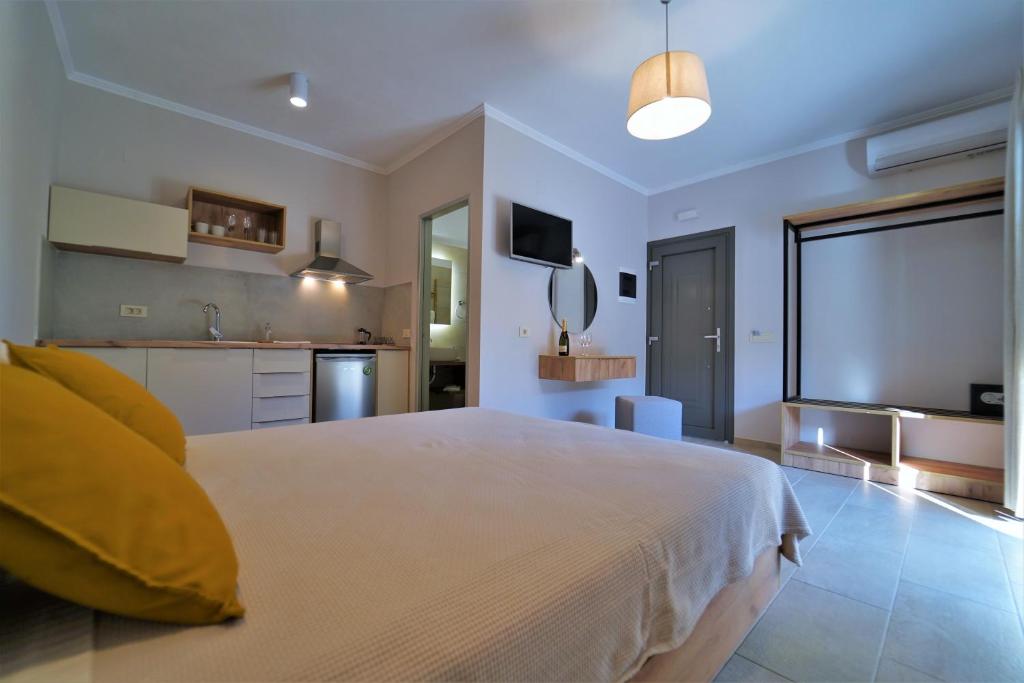 una camera con un grande letto bianco e una cucina di MERAVIGLIA a Párga