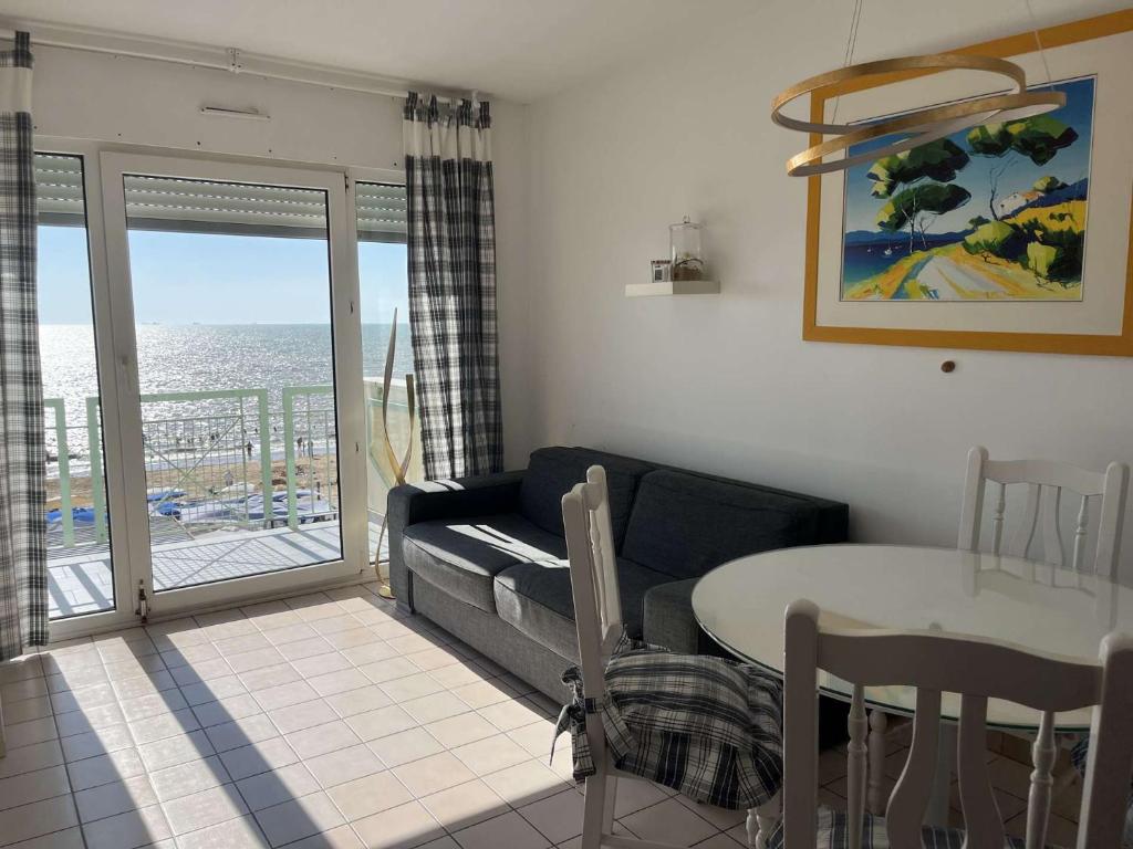d'un salon avec un canapé et une table ainsi que d'un balcon. dans l'établissement Appt 2 pièces CHATELAILLON PLAGE - CL040-R24, à Châtelaillon-Plage