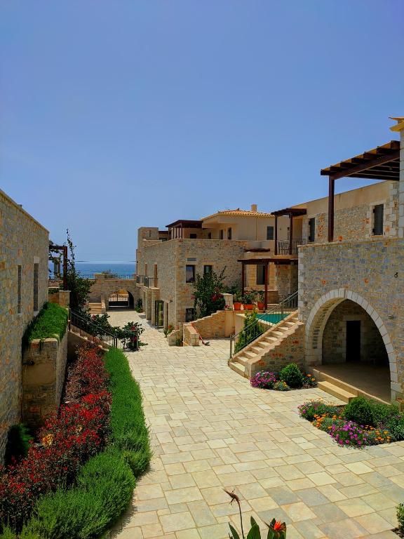 a brick walkway with flowers in front of buildings at Margo Beach Hotel in Gythio