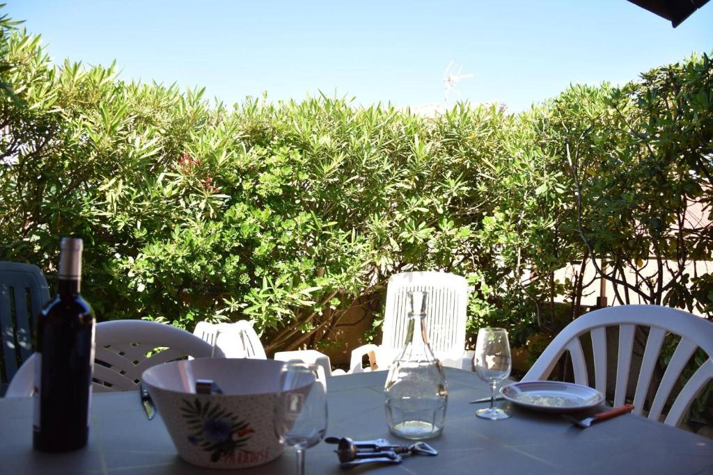 - une table avec une bouteille de vin et des verres dans l'établissement Maison Studio mezzanine Gruissan Les Ayguades AY090-003, à Vires