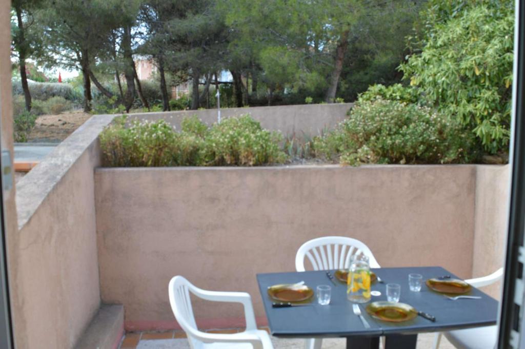- une table bleue et des chaises blanches sur la terrasse dans l'établissement NP340-H08 Appartement Studio Cabine, Narbonne Plage, à Narbonne-Plage