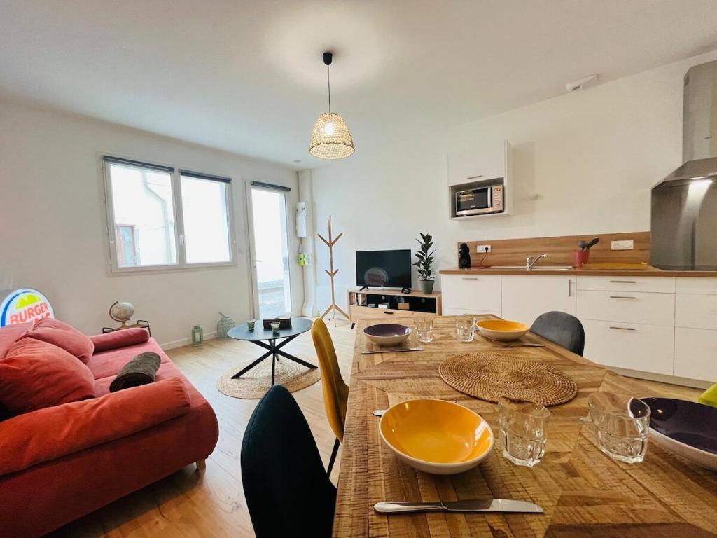 een woonkamer met een tafel en een bank bij Casa Diderot - T2 in Angers