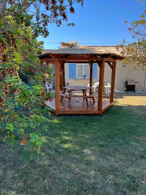 - un kiosque en bois avec une table de pique-nique dans la cour dans l'établissement La Bellevue, 15 mn de Toulouse, WIFI, Barbecue, à Labarthe-sur-Lèze