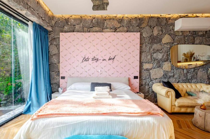 Giường trong phòng chung tại Dolce Lava - Luxury LavaStone Suite
