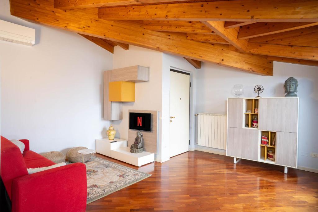a living room with a red couch and a fireplace at Terrazza incanto, con terrazza e garage in Desenzano del Garda