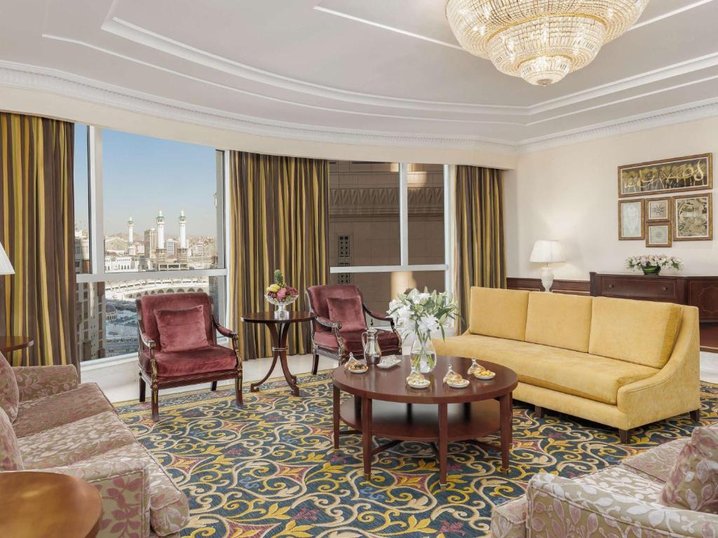 a living room with a couch and a table and chairs at Swissotel Al Maqam Makkah in Mecca