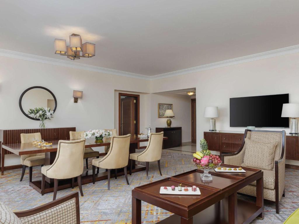 a hotel room with a dining area and a living room at Swissotel Al Maqam Makkah in Mecca